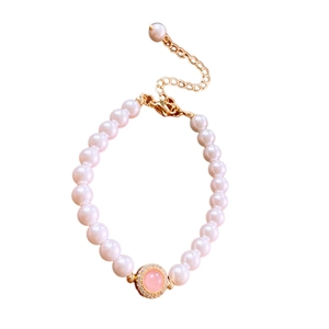 Bracelet de perles doré élégant avec pierre rose centrale et accents de zircons
