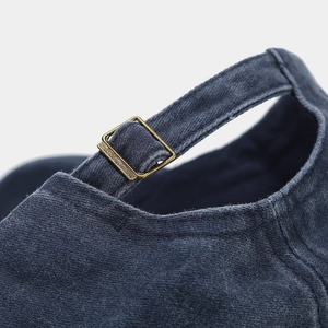 Dettaglio della fibbia in ottone regolabile e del cotone lavato blu navy sul retro