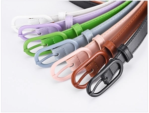 Close-up of thin PU leather belts with oval buckles in multiple macaron colors