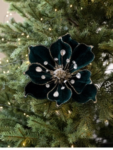 Detail of dark green velvet magnolia flower with gold glitter edges and rhinestone center