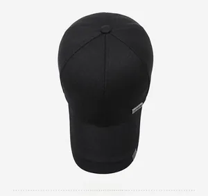 Top view of classic black cotton baseball cap showing twill texture and metal emblem