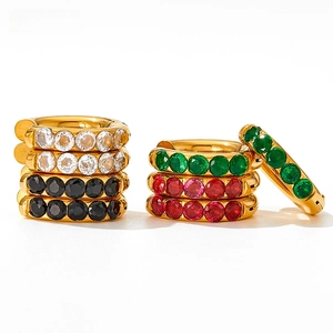 Macro shot of 18K gold plated huggie hoops featuring emerald and ruby cubic zirconia gems