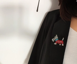 Detailed view of a crystal-encrusted Scottish Terrier brooch on a black blazer lapel