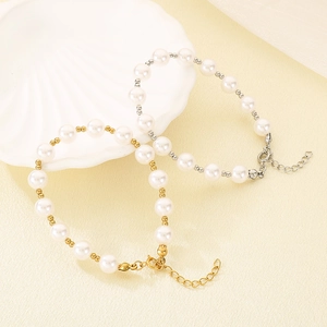 Elegant pearl bracelets with gold and silver accents displayed on a white shell plate