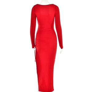 Détail de la fente haute et du laçage sur une robe longue moulante rouge à manches longues
