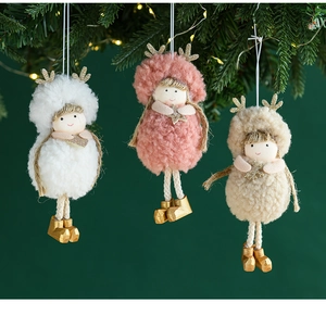 Detailed view of plush Christmas girl ornaments hanging on a festive tree branch