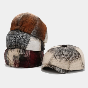 Detail of herringbone tweed newsboy hats with vintage plaid patterns and textured wool blend