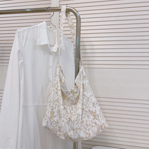 Detailed shot of floral canvas crossbody bag with cute rabbit prints on a white dress