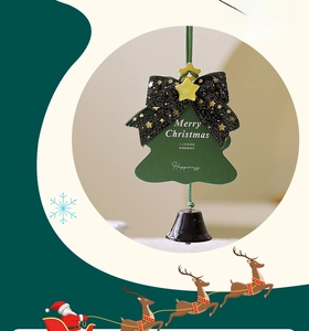 Detail of creative Christmas tree ornament with black bow, metal bell and festive card