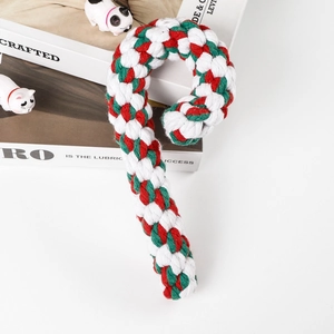 Close-up of candy cane shaped dog toy made of woven red white and green cotton rope