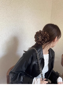 Detailaufnahme der Blumen-Haarklammer mit Leopardenmuster am Modell in Seitenansicht