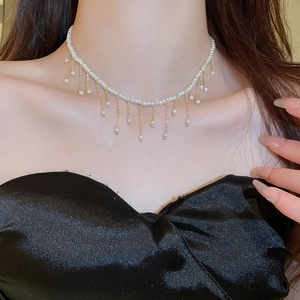 Elegant pearl choker necklace with gold-plated tassels on a model neck