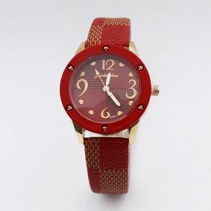 Close-up of vintage quartz watch with dark red dial and gold textured leather strap