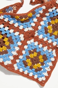 Close-up of crochet daisy triangle bandana with colorful grandmother square patterns