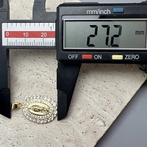 Macro shot showing the 27.2 mm length measurement of the golden Virgin Mary pendant