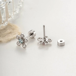 Silver daisy stud earrings in titanium steel with light blue gemstone and screw back