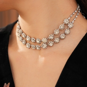 Close-up of double-layered silver diamond necklace showing high-gloss floral tassel detail