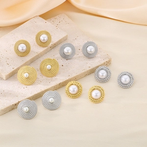 Detailed view of assorted retro pearl earrings with textured gold and silver frames