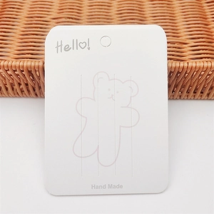 White cardboard jewelry display card with Hello Bear print for hair clips and necklaces
