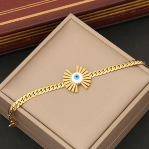 Goldenes Evil-Eye-Armband mit blau-weißem Muster auf einem edlen Schmuckkästchen