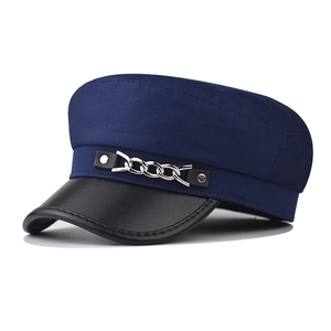 Détail de casquette gavroche bleu marine avec visière en simili cuir et chaîne argent