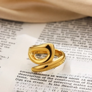 Macro shot of 18K gold knot ring with irregular abstract curves and metallic finish