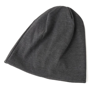 Close-up of fine ribbed texture and elastic knit on a dark grey slouchy beanie cap