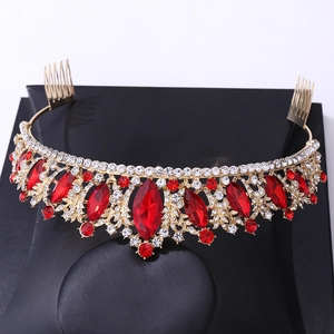 Detail showing red oval gemstones and clear crystals on a gold bridal crown with combs