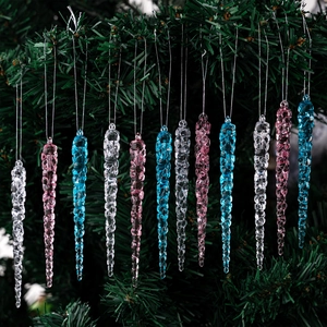 Detailed view of clear, pink and blue acrylic icicle ornaments on Christmas tree
