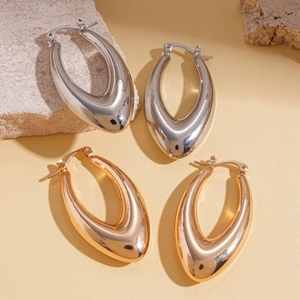 Polished metal water drop earrings in silver and rose gold on a natural stone base
