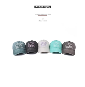 Five washed cotton baseball caps with floral embroidery and motivational text on white background