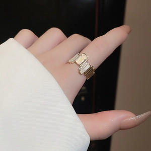 Detailed close-up of gold plated irregular geometric ring with zircon and shell inlay