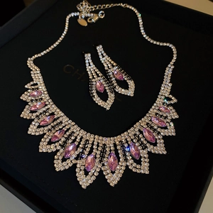 Macro detail of silver tassel necklace with pink crystals in a black jewelry gift box