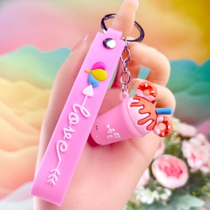 Close-up of pink milkshake cup keychain with a love-printed silicone wristlet strap