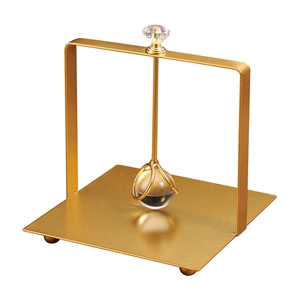 Golden luxury metal napkin holder with crystal ball accent and sleek square base design