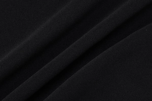 Détail macro du tissu en maille tricotée noire avec une texture fine et un beau drapé