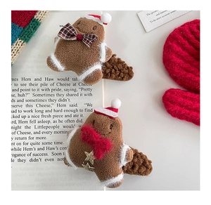 Close-up of plush gingerbread man hair clips on festive red and white background