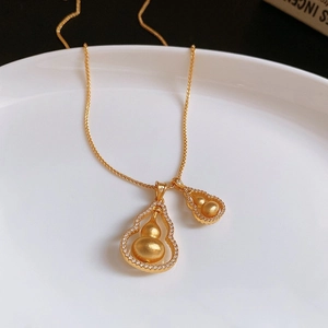 Dettaglio della collana a doppia zucca dorata con zirconi e finitura opaca su ceramica