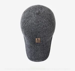 Close-up of dark grey woven texture with a brown leather patch on an elderly men's cap