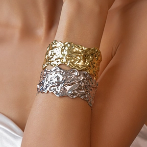 Detail of wide open cuff bracelets with molten lava texture in gold and silver finish