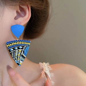 Detailed view of bohemian geometric drop earrings with blue floral tribal patterns