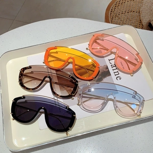 Modern oversized shield sunglasses in orange, pink, and leopard print on a magazine