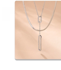 Macro shot of double-layer silver chain with a hollow rectangular zircon pendant