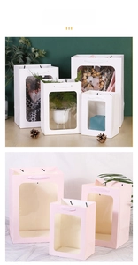 Detailed view of white and pink paper gift bags with large clear windows and handles