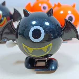 Close-up of wind-up bat monster toy with yellow tusks and single eye for Halloween