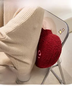Detail of red and pink heart plush cushion with embroidered letters on a chair