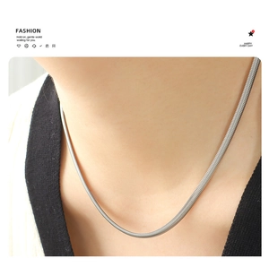 Detailopname van minimalistische zilveren slangenketting op de hals met structuur