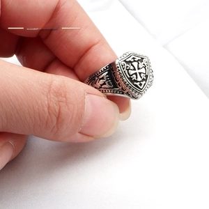 Gros plan d'une bague chevalière croix rétro en argent avec détails en relief noirci
