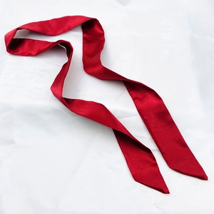 Macro detail of red bohemian silk ribbon accessory with elegant satin finish for bags