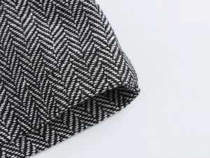Close-up macro of elegant black and white herringbone wool blend suit fabric texture